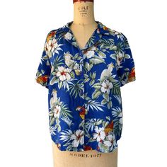 "Sarah Bentley Women's Hawaiian Parrot Shirt Blouse Blue Tropical Floral M Size Medium Short Sleeve  Spread Collar White Tropical Floral  Macaw Parrot Print 100% Rayon Machine Washable Preloved Measurements Chest 44\" Waist 42\" Length 23\" Shoulder to Shoulder 17\"" Hawaiian V-neck Top With Tropical Print, Blue Camp Collar Top For Beach, Blue Collared Blouse For Vacation, Blue Camp Collar Tops For The Beach, Tropical Relaxed Fit Tops, Hawaiian Short Sleeve Blouse For Vacation, Blue Collared Top For Beach, Blue Blouse With Camp Collar And Relaxed Fit, Blue Blouse With Relaxed Fit And Camp Collar