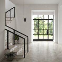 an empty room with wooden floors and black glass doors that lead to a large balcony