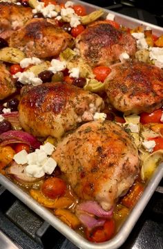 a pan filled with chicken and vegetables on top of a stove