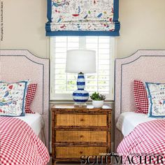 two beds in a bedroom with red and white checkered sheets on the bedding