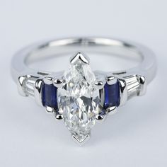 a white gold ring with an oval cut diamond and three baguettes on the side