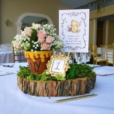 a table topped with a potted plant next to a sign