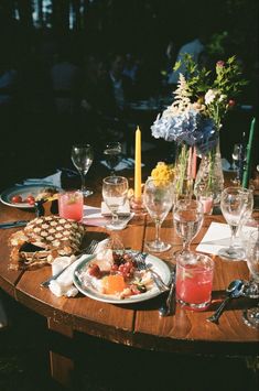 a wooden table topped with plates and glasses