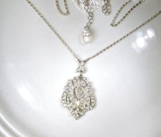 "Offering a beyond gorgeous authentic antique 1920s - 1930s era Art Deco French paste pave crystal rhinestone pendant lavaliere necklace perfect for the bride. This stunning flapper necklace is absolutely gorgeous! Necklace features a beautifully designed open work pot metal pendant that is pave set with baguette and round cut clear sparkly crystal rhinestones. The pendant hangs from a lacy rhinestone adorned leaf shaped link that adds even more interest and sparkle. When I found this treasure, Silver Vintage Bridal Necklace, Antique Silver Bridal Necklace For Wedding, Antique Bridal Necklace With 17 Jewels For Wedding, Victorian Wedding Jewelry With Rhinestones, 1930s Wedding, Flapper Necklace, Vintage Rhinestone Jewelry, Wedding Pendant, Rhinestone Art