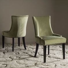 two green chairs sitting next to each other on top of a white carpeted floor