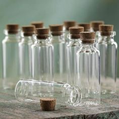 several empty glass bottles with corks on a wooden table