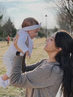 a woman holding a baby up to her face