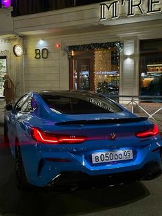 a blue sports car parked in front of a building