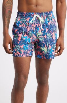 Lightweight and stretchy, these pool-to-party swim trunks feature plenty of handy pockets plus interior compression shorts for easy, supportive comfort. 5 1/2" inseam; 23 1/2" leg opening Elastic/drawstring waist Side-seam pockets; back welt pocket Interior compression shorts 91% polyester, 9% spandex Machine wash, tumble dry Imported Pink Swim Trunks With Built-in Shorts For Beach Season, Tropical Swim Trunks With Built-in Shorts For Poolside, Swim Trunks With Built-in Shorts For Poolside, Beachy Fitted Swim Trunks For Swimming, Fitted Beachy Swim Trunks For Swimming, Fitted Tropical Swim Trunks For Pool, Hawaiian Swimwear With Built-in Shorts For Swimming, Tropical Swimwear With Built-in Shorts For Swimming, Hawaiian Style Short Swimwear For Swimming