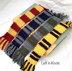 three knitted scarves with tassels on top of each one in different colors