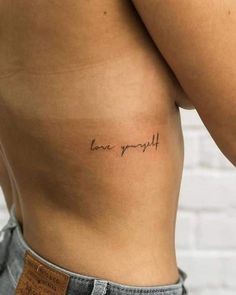 a woman's stomach with the words love yourself written on it, in cursive font