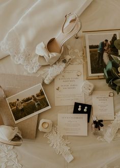 the wedding stationery is laid out on top of the bed with bride's shoes