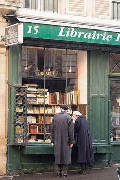 two men standing in front of a book store