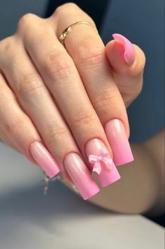 a woman's hand with pink and white manies on it, holding a ring