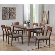 a dining room table with six chairs and a painting on the wall in the background