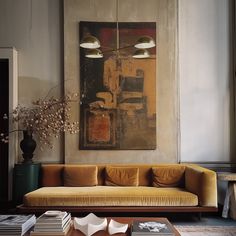 a living room filled with furniture and a painting hanging on the wall above it's head