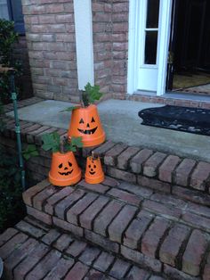 three orange plastic pumpkin cups sitting on the steps