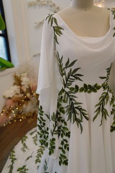 a white dress with green leaves on it