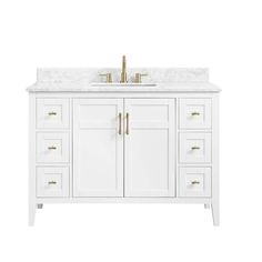 a white bathroom vanity with two sinks and gold faucets