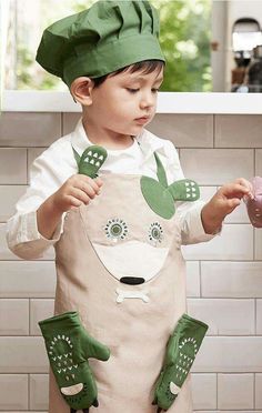 a young boy wearing an apron and hat