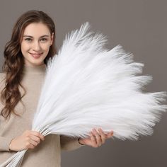 a woman holding white feathers in her hands