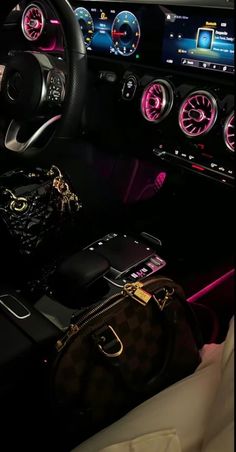 the interior of a luxury car is lit up with pink and black lights, including gauges