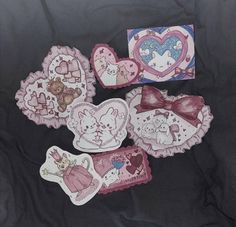 some pink and white heart shaped magnets on a black cloth background with other valentine's day decorations