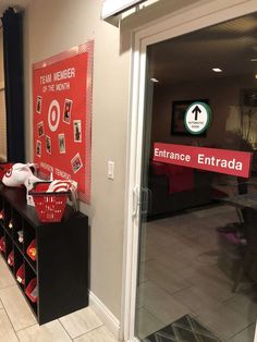 there is a red and white sign on the wall in front of an entrance area