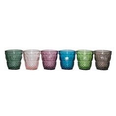 six different colored glass cups lined up in a row on a white background with one empty