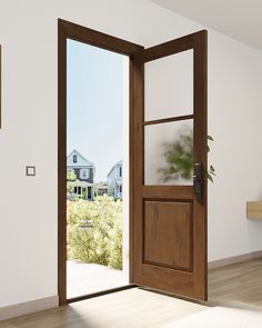 an open wooden door in a white room with wood flooring and windows looking out onto the front yard