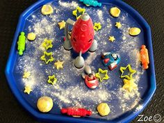 a blue tray with toys on it and stars all over the surface, including a toy rocket ship