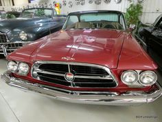 several classic cars are parked in a garage