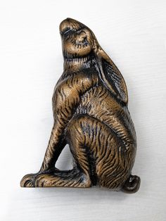 a bronze colored statue of a sitting cat