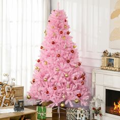 a pink christmas tree in a living room next to a fire place with presents on the floor