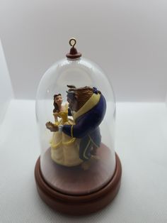 a snow globe with a figurine in the shape of a man and woman kissing