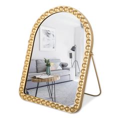 a mirror that is on the ground in front of a table with a coffee table