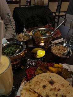 a table topped with lots of food next to cups and bowls filled with soups