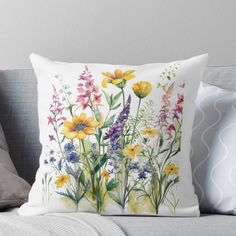 a watercolor painting of wildflowers and daisies on a white background throw pillow