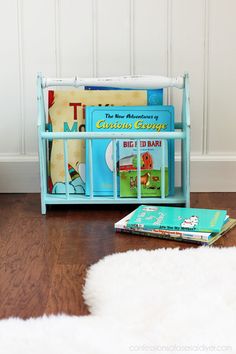 there is a book rack on the floor next to some children's books and magazines