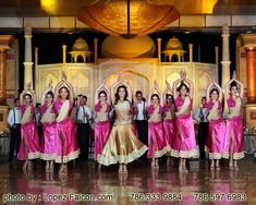 a group of women standing on top of a floor in front of a stage with their hands up