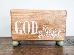 a wooden sign with the word god is beautiful on it sitting on top of a table