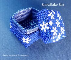 a close up of a blue and white beaded bow tie on a blue surface