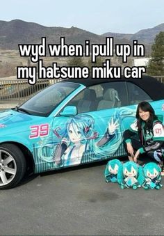 a woman sitting on the ground next to a car with anime characters painted on it