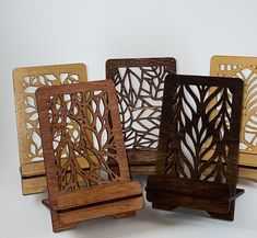 four wooden coasters with laser cut designs on the front and back, sitting side by side