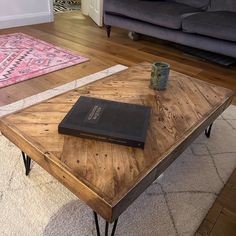 a coffee table with a book on it and a rug in front of the couch