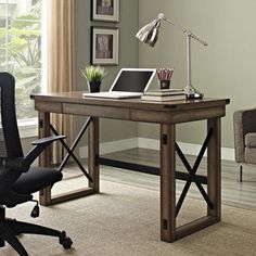 a desk with a laptop on it and a chair in front of the table next to it