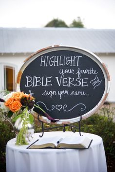 a table with a sign and flowers on it that says, highlight your favorite bible verse