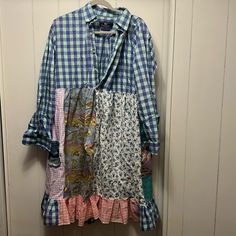 a blue and white checkered shirt hanging up on a door way with other clothes