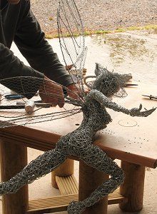 a man is working on some wire sculptures