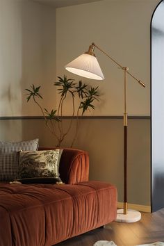 a living room with a couch, lamp and rugs on the floor in front of it